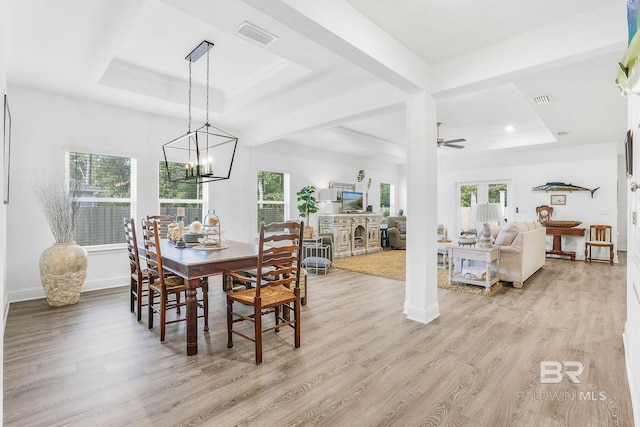 dining area featuring a raised ceiling, light wood-style flooring, a chandelier, ceiling fan, and recessed lighting