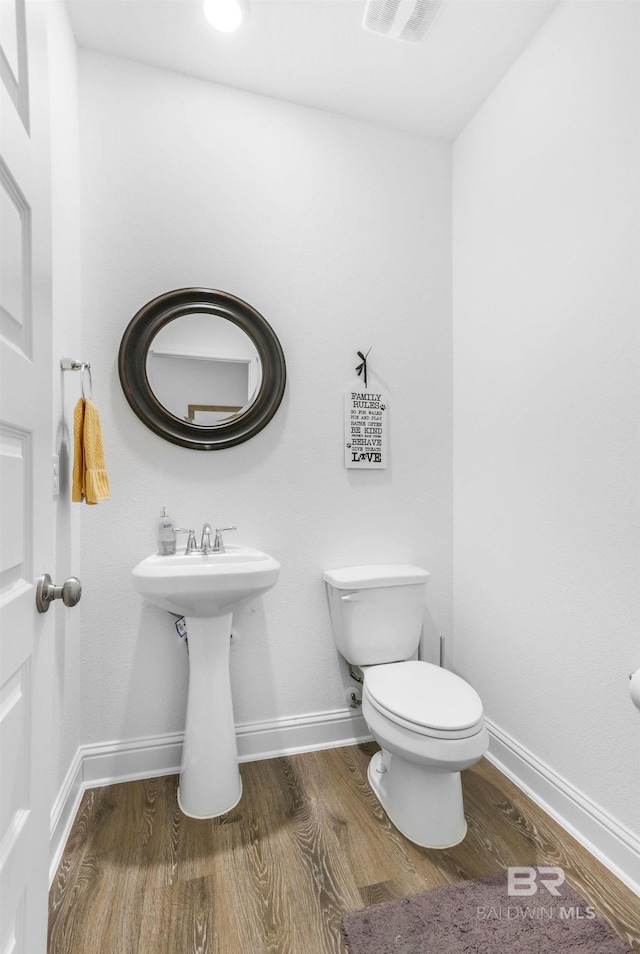 bathroom featuring wood finished floors, toilet, and baseboards