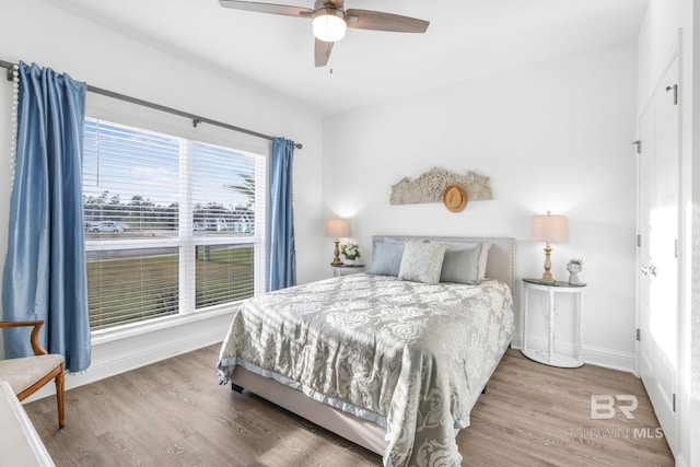bedroom with wood finished floors, a ceiling fan, and baseboards