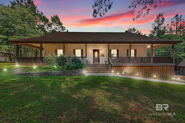 view of front of home featuring covered porch and a yard