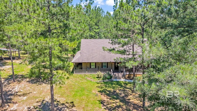 back of house featuring a lawn and covered porch