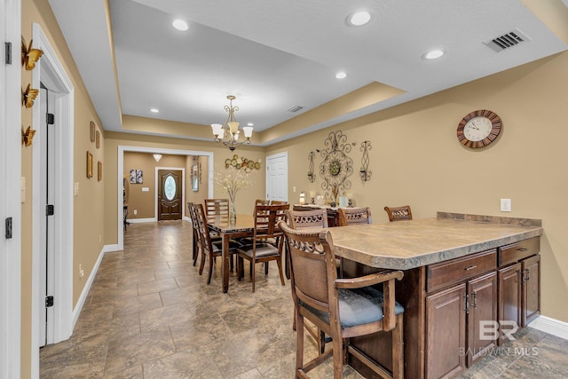 dining room featuring a raised ceiling and a chandelier