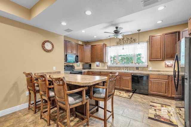 kitchen featuring ceiling fan, black appliances, kitchen peninsula, sink, and hanging light fixtures