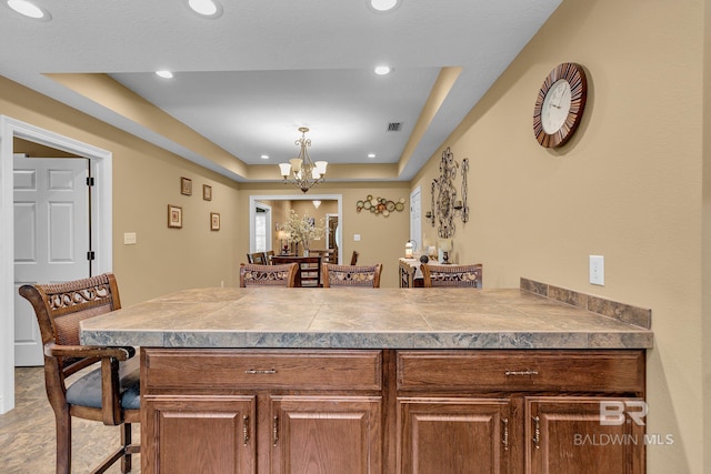 kitchen with a kitchen bar, hanging light fixtures, and a chandelier