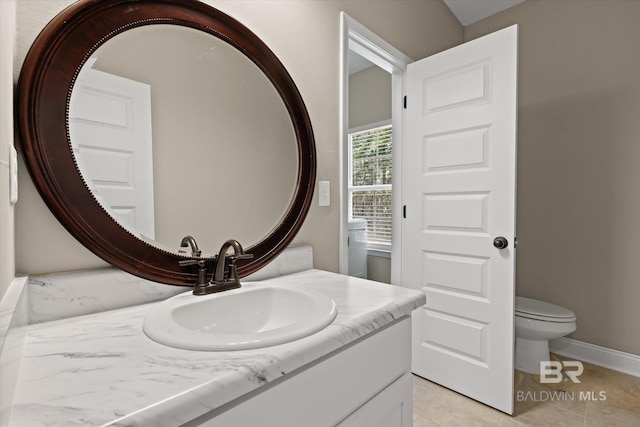 bathroom with tile patterned flooring, vanity, and toilet