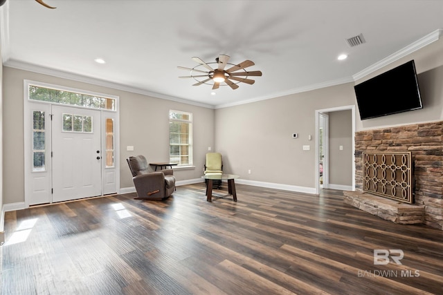 living area with ceiling fan, crown molding, and a wealth of natural light