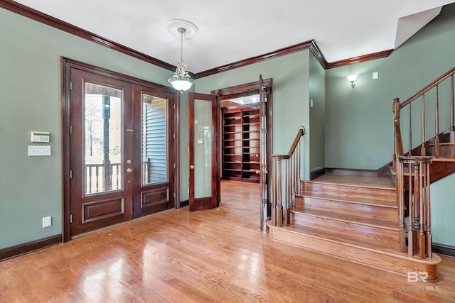 foyer featuring stairs, baseboards, wood finished floors, and french doors