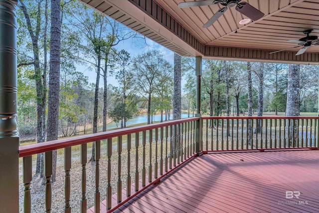 wooden deck with a water view and a ceiling fan