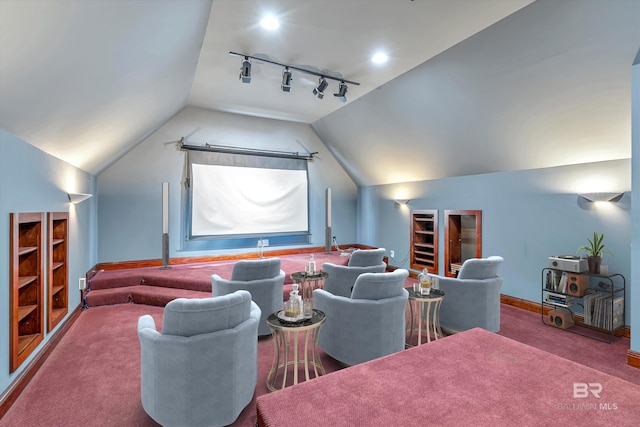 carpeted home theater with lofted ceiling, rail lighting, and baseboards