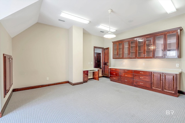 kitchen with light colored carpet, light countertops, visible vents, glass insert cabinets, and vaulted ceiling