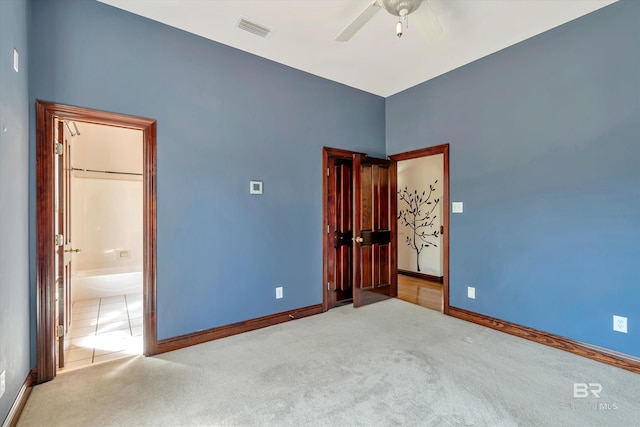 empty room featuring baseboards, visible vents, a ceiling fan, and light colored carpet