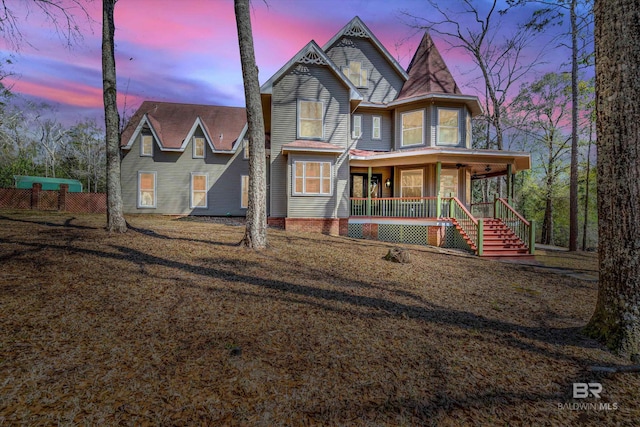 victorian-style house featuring covered porch and stairs