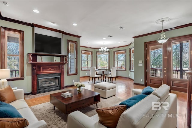 living room with recessed lighting, a healthy amount of sunlight, light wood-style flooring, and baseboards