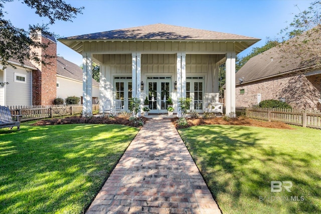 bungalow with a front lawn and french doors