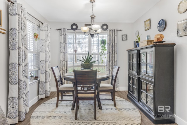 dining area featuring wood-type flooring and a chandelier