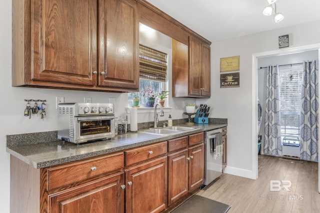 kitchen with sink, stainless steel dishwasher, and light hardwood / wood-style floors