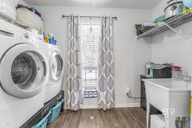 laundry area featuring sink, washer and dryer, and dark wood-type flooring