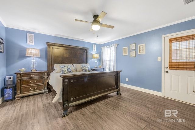 bedroom with crown molding, ceiling fan, and hardwood / wood-style floors