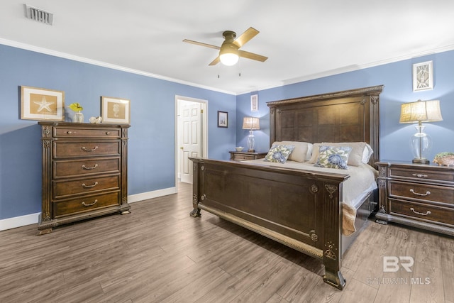 bedroom featuring ceiling fan, ornamental molding, and wood-type flooring