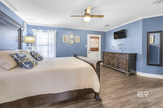 bedroom featuring crown molding, dark wood-type flooring, and ceiling fan