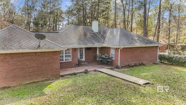 rear view of house featuring a patio and a lawn