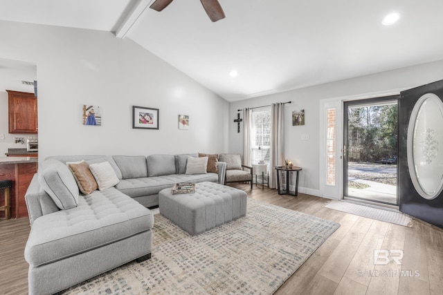 living room featuring lofted ceiling with beams, ceiling fan, and light hardwood / wood-style floors