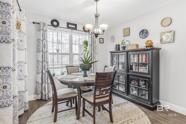 dining area with dark hardwood / wood-style flooring and a chandelier