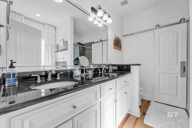 8847 Asphodel Ln, Daphne, AL 36526 - bathroom featuring double vanity, a stall shower, toilet, and wood finished floors