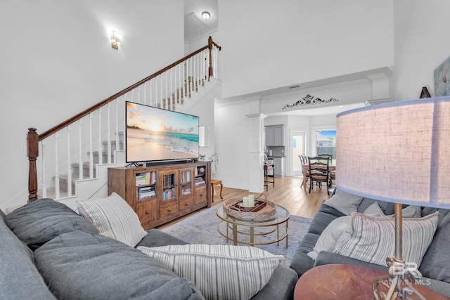 8847 Asphodel Ln, Daphne, AL 36526 - living room with a towering ceiling, light wood-style floors, stairway, and crown molding