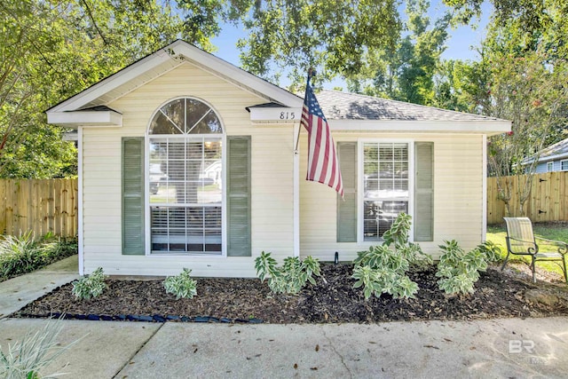 view of front of house featuring fence and a shingled roof