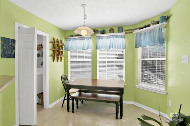 dining area featuring tile patterned floors, baseboards, and a textured ceiling