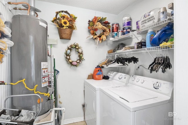 washroom with laundry area, gas water heater, washing machine and dryer, and a textured ceiling