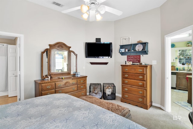 bedroom featuring visible vents, connected bathroom, ceiling fan, light colored carpet, and a sink