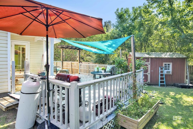 wooden terrace with an outbuilding, fence, a shed, a vegetable garden, and a yard