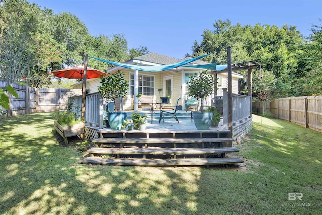 back of house featuring a yard, a wooden deck, and a fenced backyard