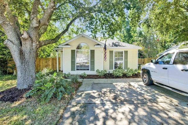 view of front of home with roof with shingles and fence