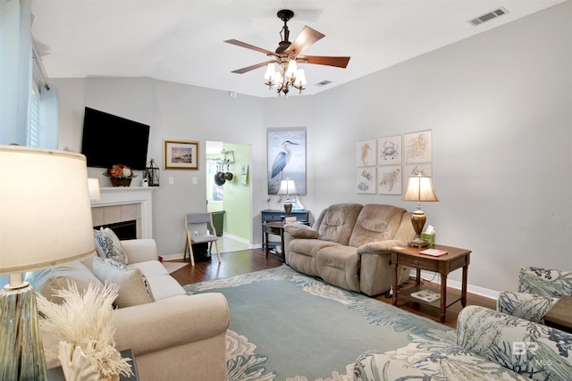 living room with a ceiling fan, baseboards, wood finished floors, visible vents, and a tile fireplace