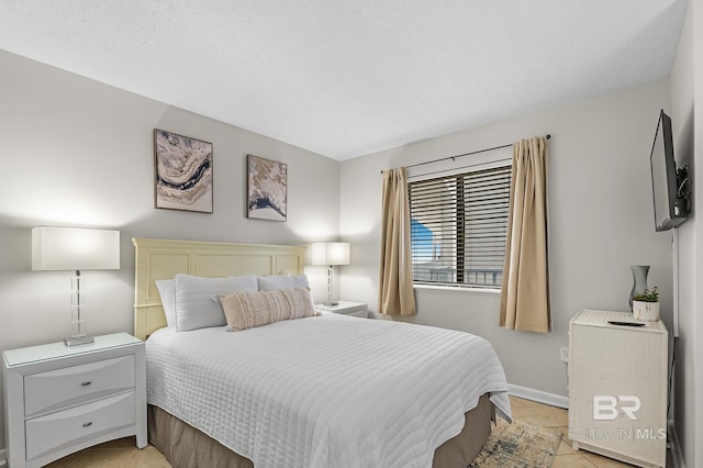 bedroom featuring a textured ceiling and light tile patterned floors