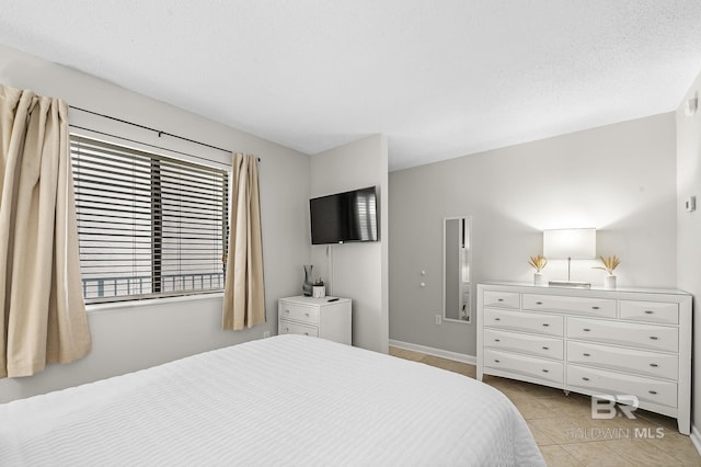 bedroom with a textured ceiling and light tile patterned flooring