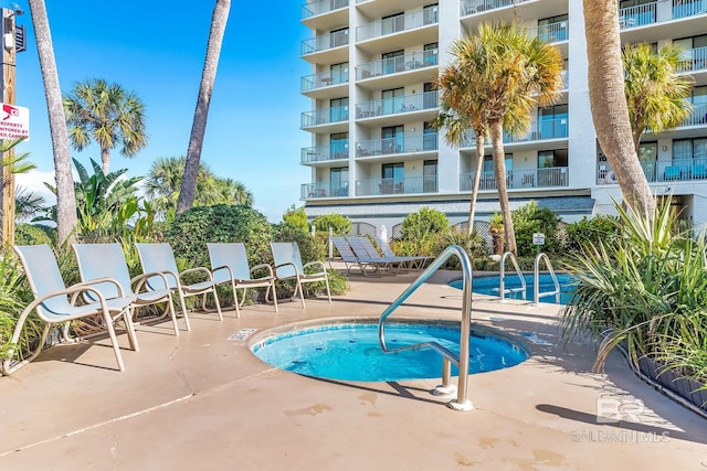 view of swimming pool with a hot tub