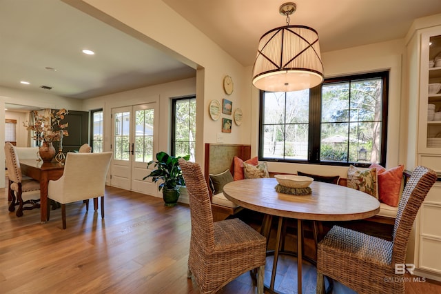 dining room featuring wood-type flooring, a wealth of natural light, and french doors