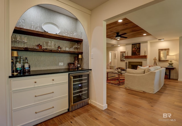 bar featuring light hardwood / wood-style flooring, wine cooler, ceiling fan, wood ceiling, and white cabinets