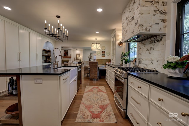 kitchen featuring white cabinetry, stainless steel range with gas stovetop, and a wealth of natural light