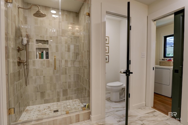 bathroom featuring washer / dryer, toilet, and walk in shower