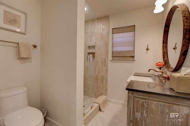 bathroom featuring vanity, toilet, tiled shower, and tile patterned floors