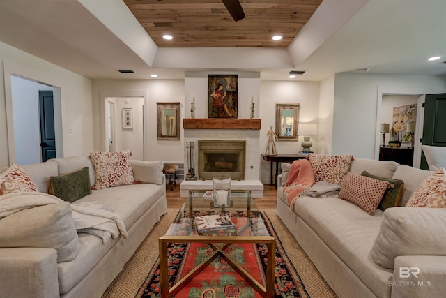 living room with a tray ceiling, wood ceiling, and light hardwood / wood-style flooring