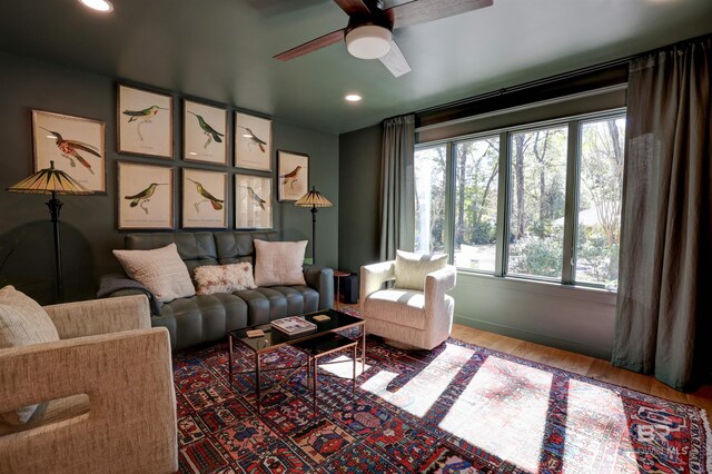 living room featuring hardwood / wood-style floors and ceiling fan