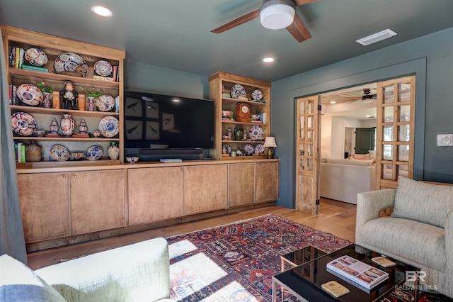 living room with hardwood / wood-style flooring and ceiling fan