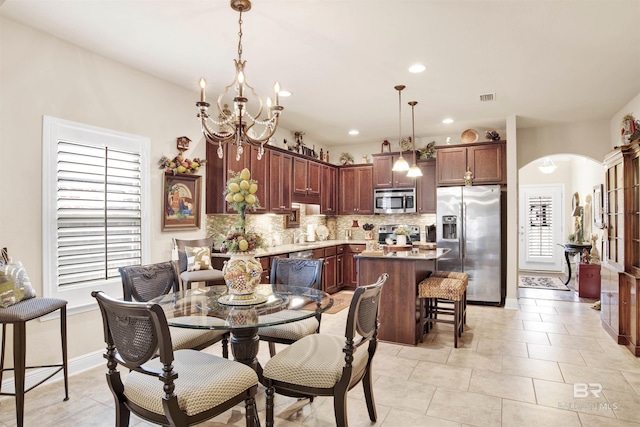 4268 Birkdale St, Gulf Shores, AL 36542 - dining space with a chandelier, arched walkways, recessed lighting, baseboards, and light tile patterned floors