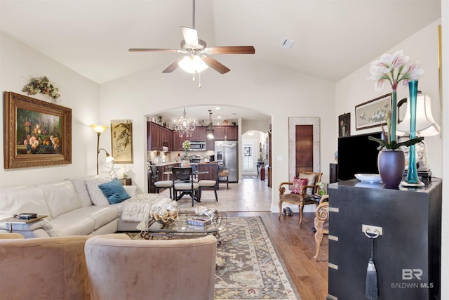 4268 Birkdale St, Gulf Shores, AL 36542 - living room with arched walkways, ceiling fan, vaulted ceiling, light wood-style floors, and a chandelier